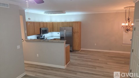 A kitchen with wooden cabinets and a marble countertop.