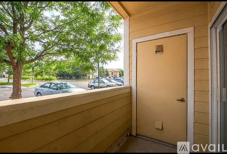 A wooden building with a door and a window overlooking a parking lot.