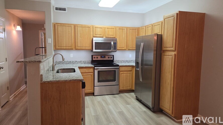 A kitchen with wooden cabinets and stainless steel appliances.