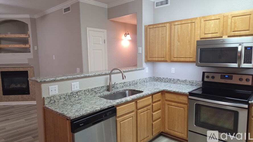 A kitchen with wooden cabinets and granite countertops.
