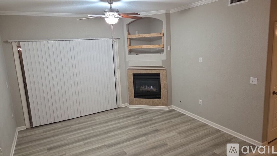 A room with a fireplace and a fan on the ceiling.