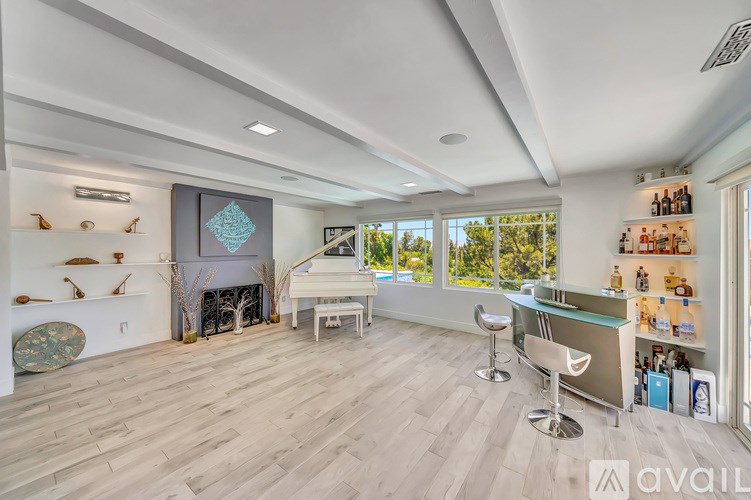 A living room with a piano and a fireplace.