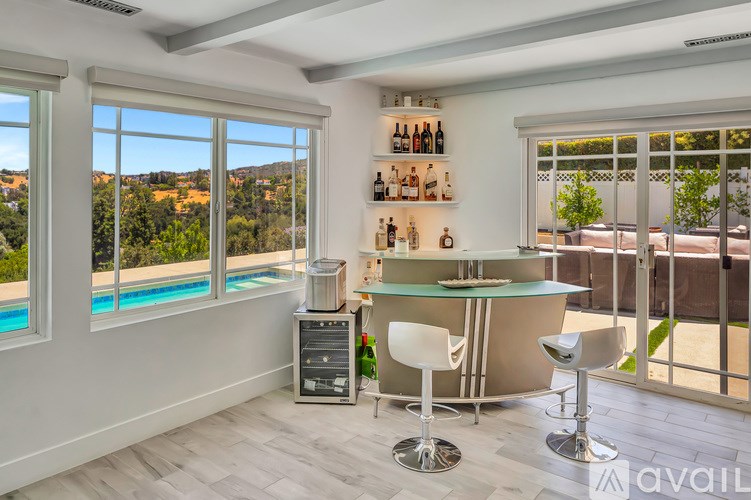 A bar area with a green bar counter and white chairs.