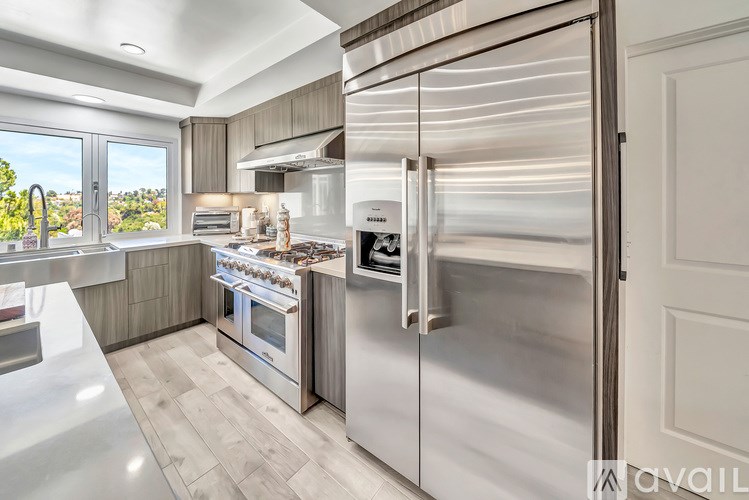 A modern kitchen with a stainless steel refrigerator and oven.