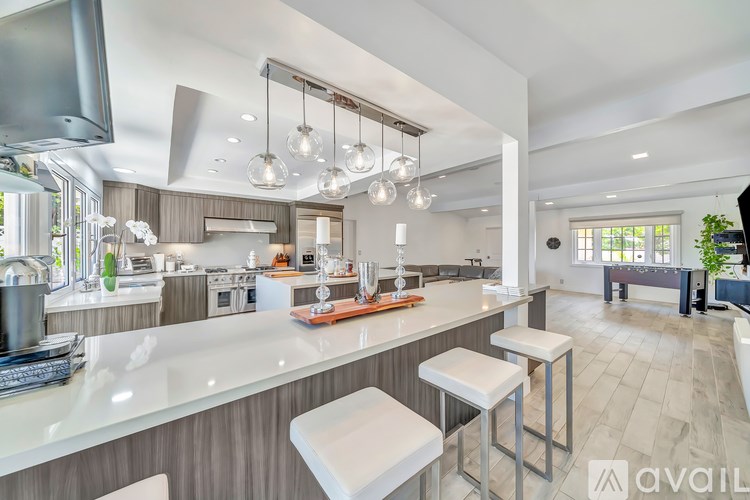 A modern kitchen with a large island and stools.