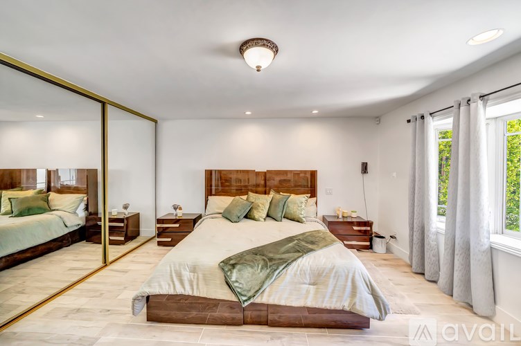 A bedroom with a large bed and a mirror on the wall.