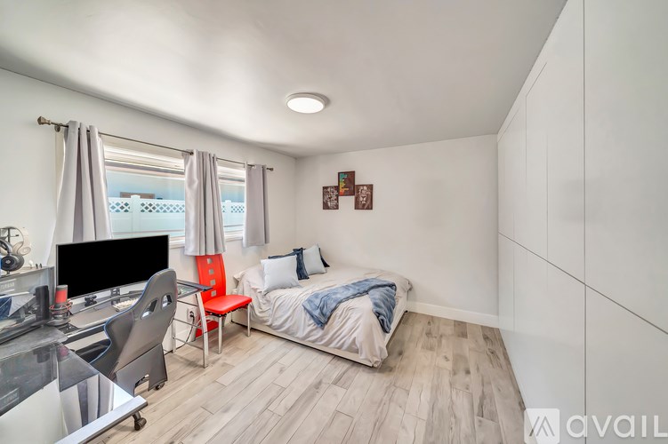 A bedroom with a bed, chair, and television.