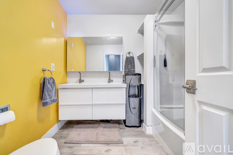 A bathroom with yellow walls and a white vanity.