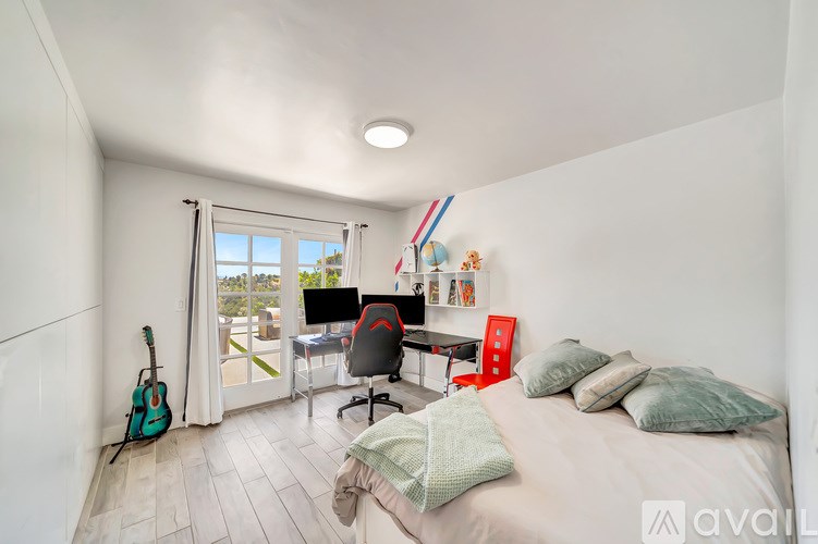 A room with a bed, desk, and chair.