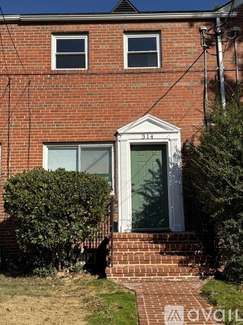 A red brick house with a white door and two windows.