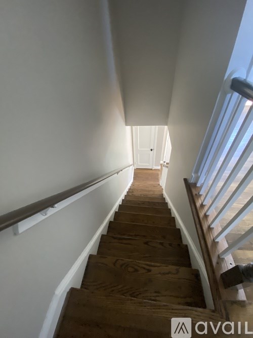 A staircase with wooden steps and white railings.