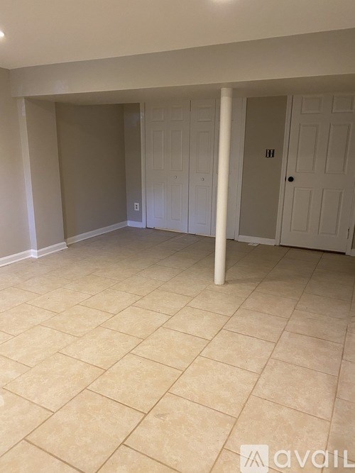 A room with a tiled floor and a white door.