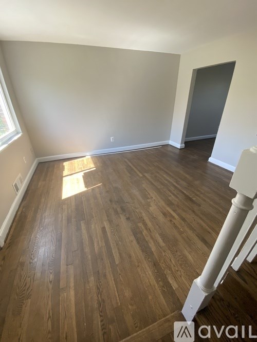 A room with wooden flooring and white walls.