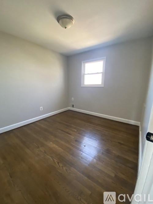 A room with wooden flooring and a window.