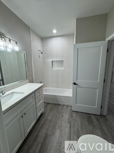 A bathroom with a white sink, a bathtub, and a white toilet.