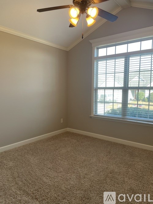 A room with a ceiling fan and a window with blinds.