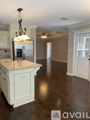 A kitchen with a granite countertop and a chandelier.