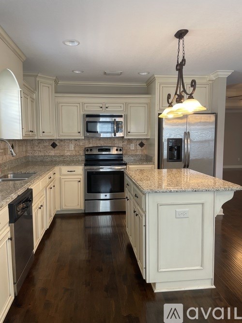 A kitchen with a granite countertop and stainless steel appliances.