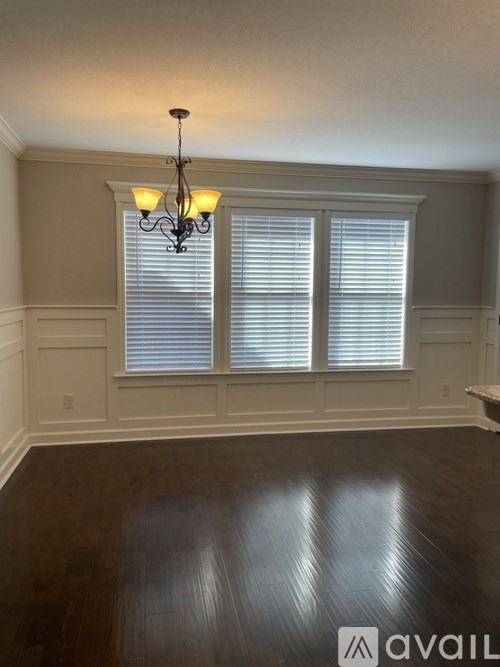 A room with wooden floors and a chandelier.