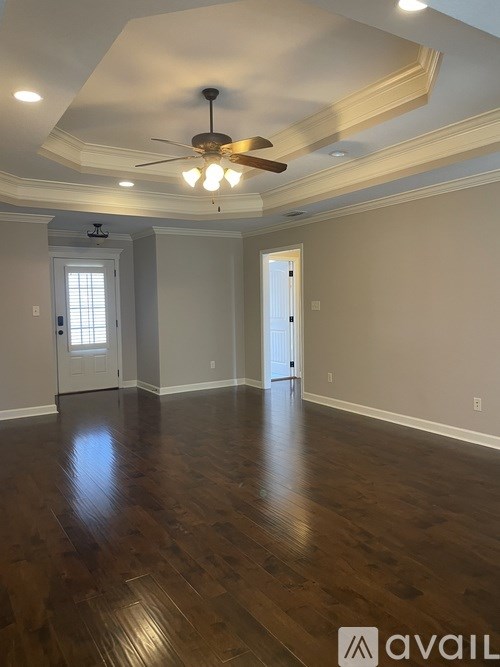 A room with wooden floors and a ceiling fan.