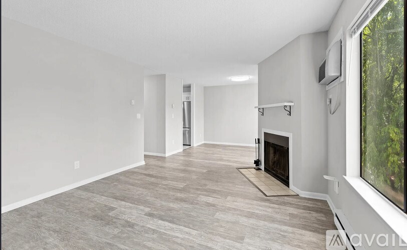 A spacious living room with a fireplace and a large window.
