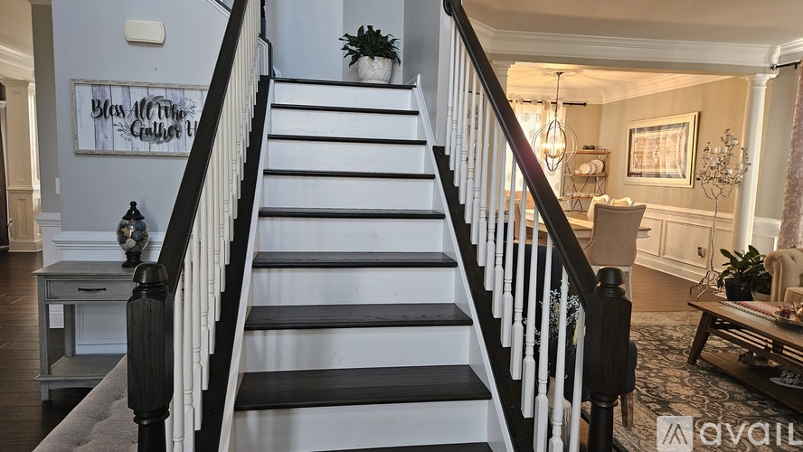 A staircase with a black railing and white steps.