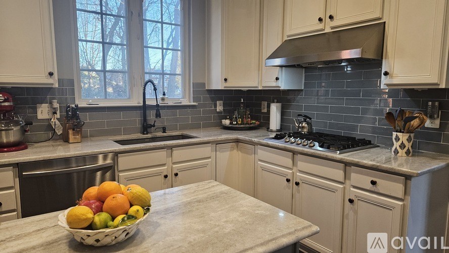 A kitchen with a bowl of fruit on the counter.