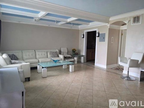 A living room with a white couch and a glass coffee table.
