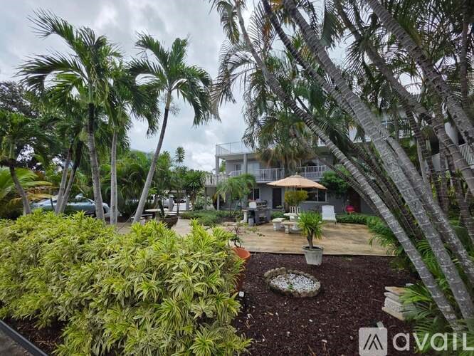 A tropical garden with a house in the background.