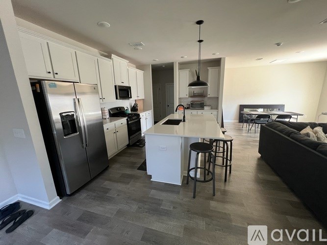 A modern kitchen with a refrigerator, microwave, oven, and sink.