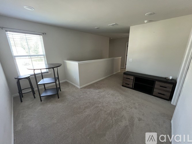 A room with a table and chairs by a window.