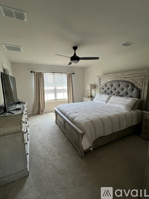 A bedroom with a large bed and a television.