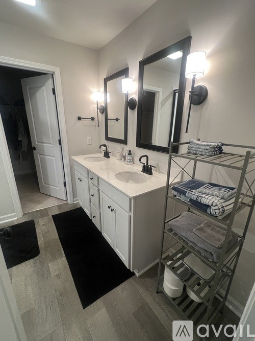 A bathroom with a sink, mirror, and towel rack.
