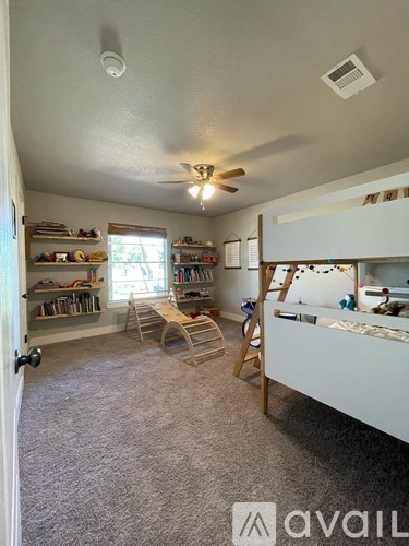 A room with a ceiling fan and a bunk bed.