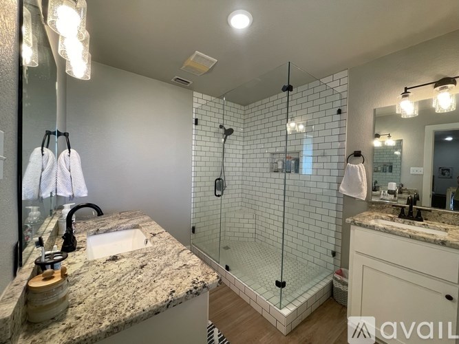 A bathroom with a marble countertop and a walk-in shower.