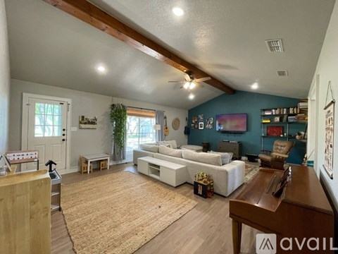 A living room with a white couch and a wooden table.