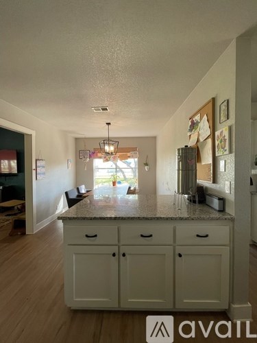 A kitchen with white cabinets and a granite countertop.