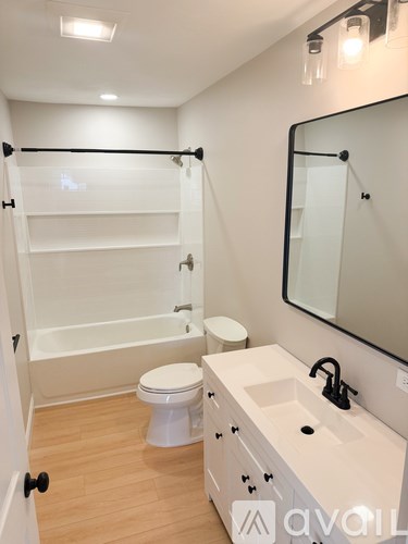 A white bathroom with a toilet, sink, and bathtub.