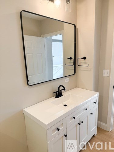 A bathroom with a white vanity and a large mirror.