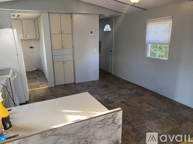 A room with a marble table and wooden flooring.