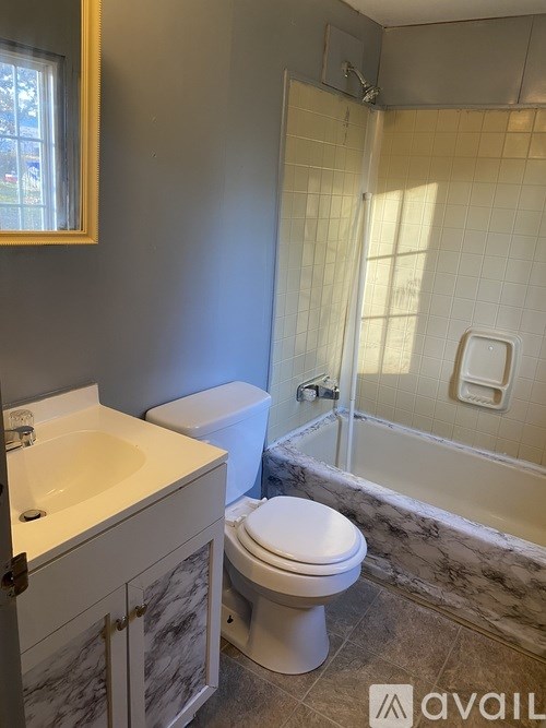A bathroom with a toilet, sink, and shower.