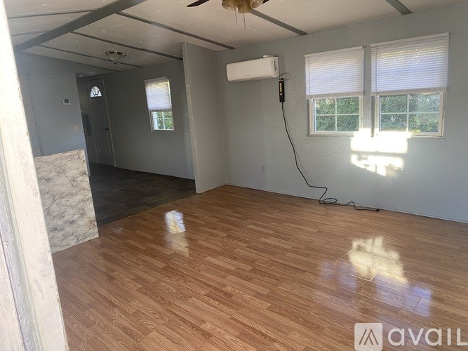A room with wooden flooring and a ceiling fan.