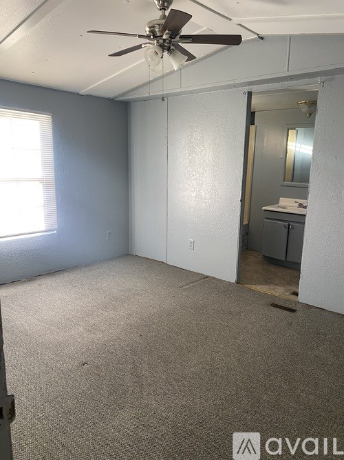 A room with a ceiling fan and a carpeted floor.