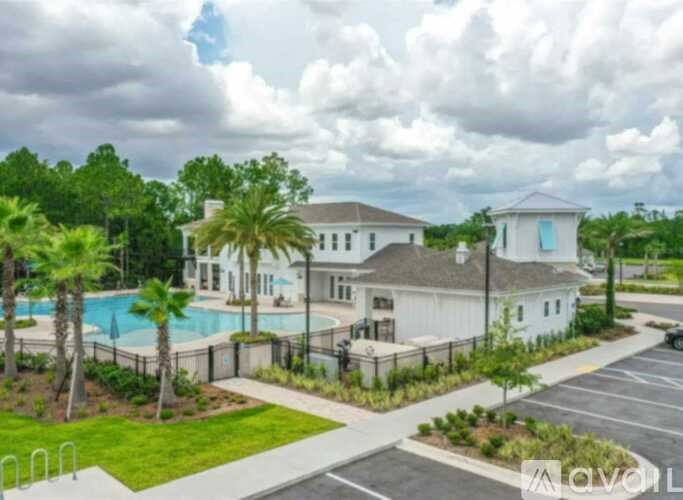 A white building with a pool in front of it.