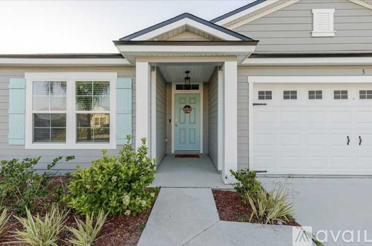 A house with a blue door and a white garage door.