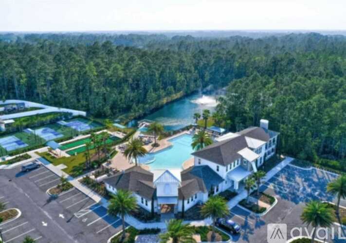 A bird's eye view of a resort with a swimming pool and a river in the background.