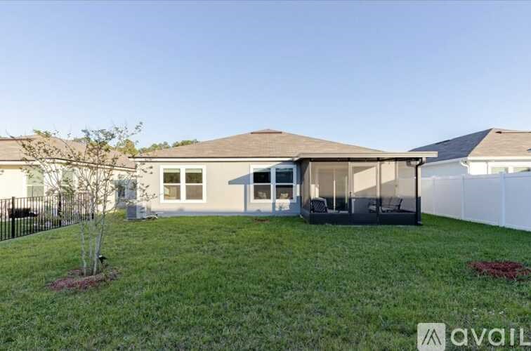 A house with a lawn and a tree in front of it.