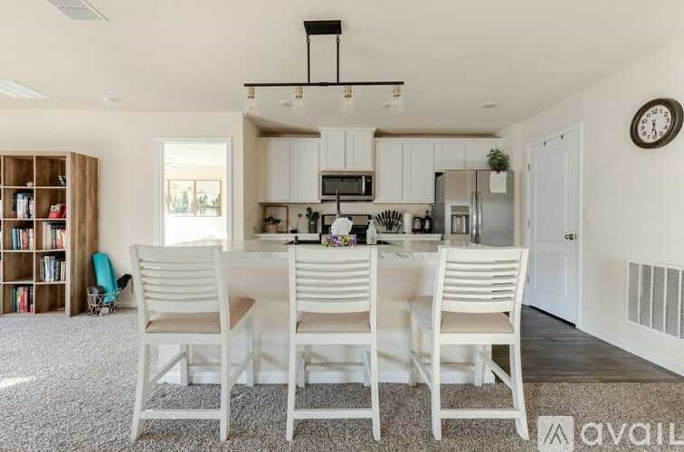 A kitchen with white chairs and a white table.