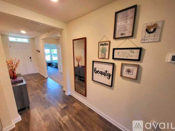 A hallway with a mirror and framed pictures on the wall.