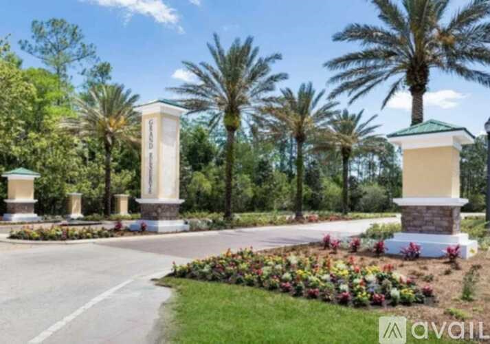 A garden with a white pillar and a green roofed pillar surrounded by trees.